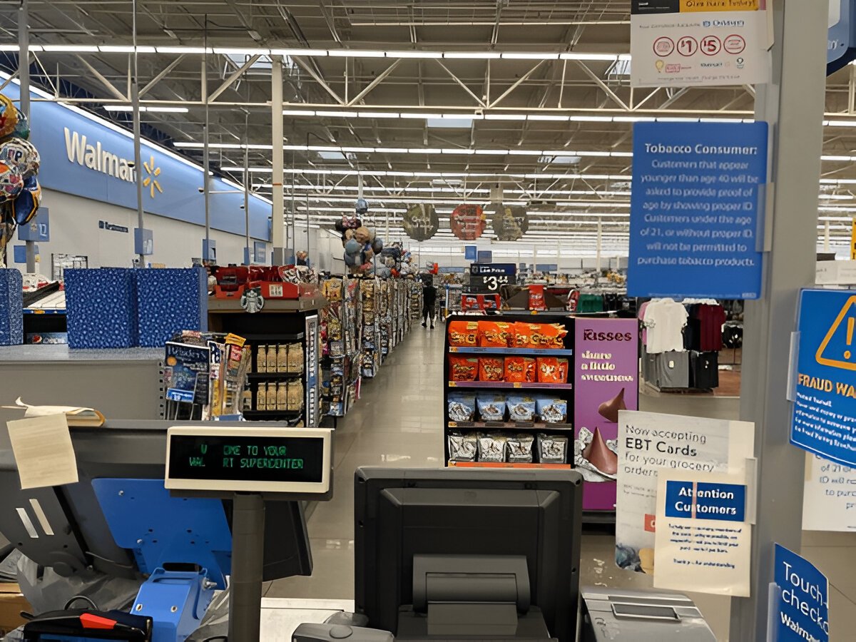 Walmart checkout area with registers and signage.